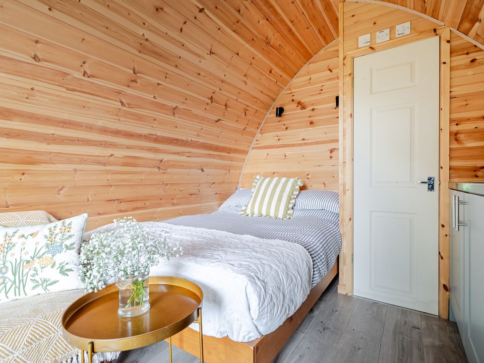 A bedroom with a bed and sofa at Peaceful pod with bay views, walk to 3 beaches, St Ives