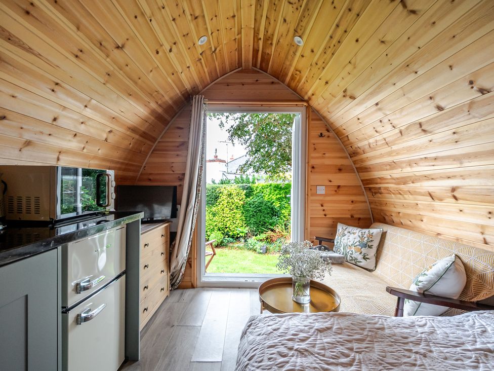 A cozy space with kitchenette and seating at Peaceful pod with bay views, walk to 3 beaches in St Ives