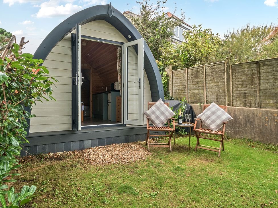 A garden with an outdoor pod and chairs at Peaceful pod with bay views, walk to 3 beaches St Ives