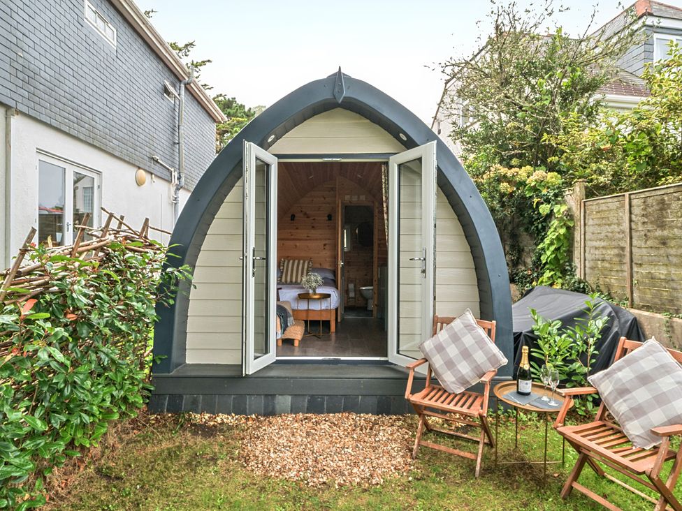 A garden with a pod structure and seating area at Peaceful pod with bay views, walk to 3 beaches St Ives