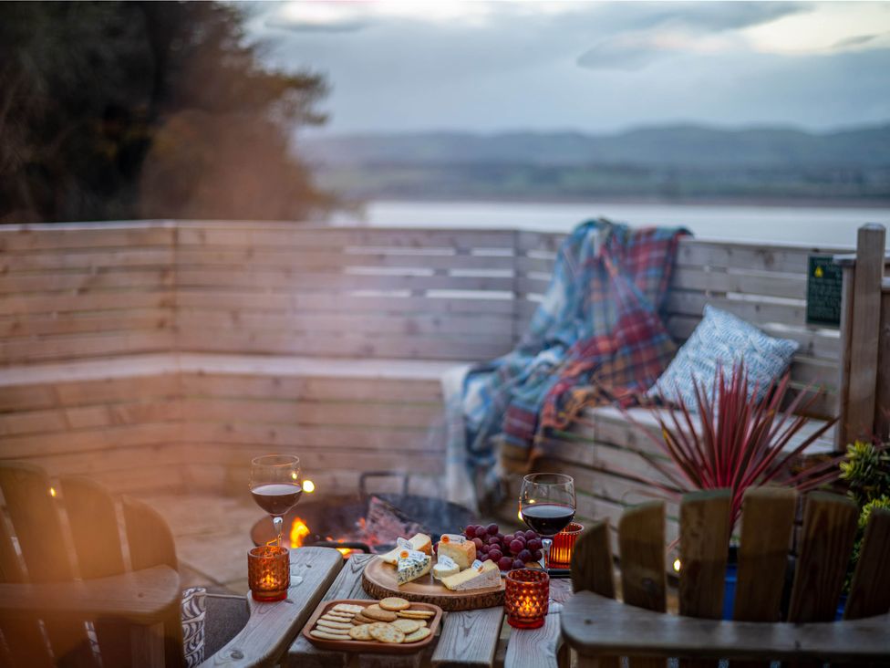 An outdoor seating area with a food platter and wine at tbc 