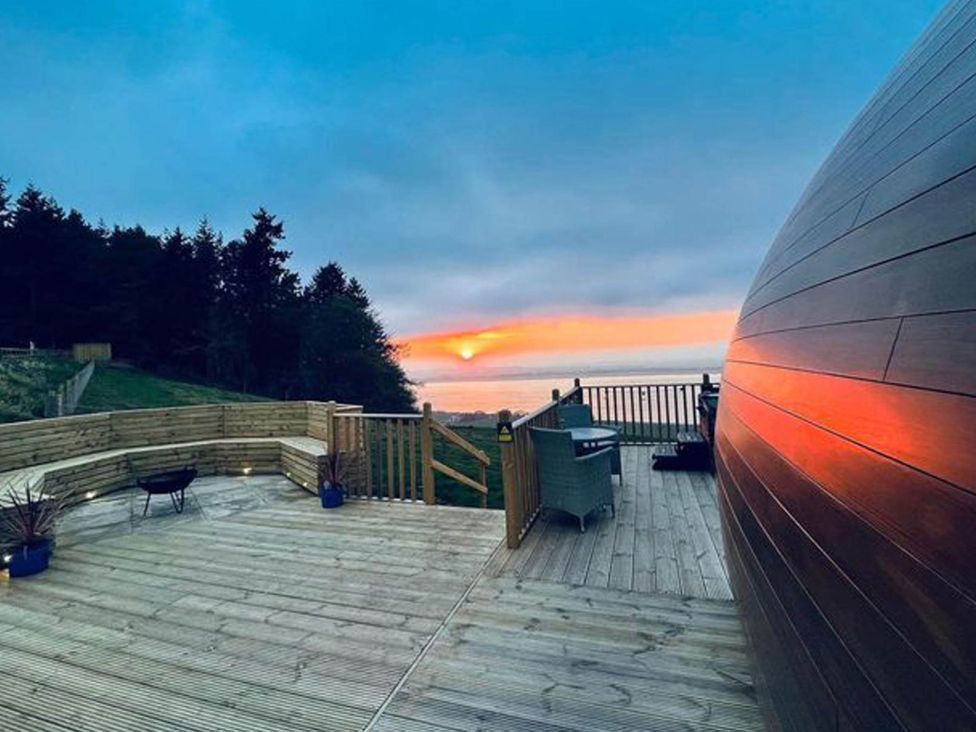 A deck with furniture overlooking the sea at tbc