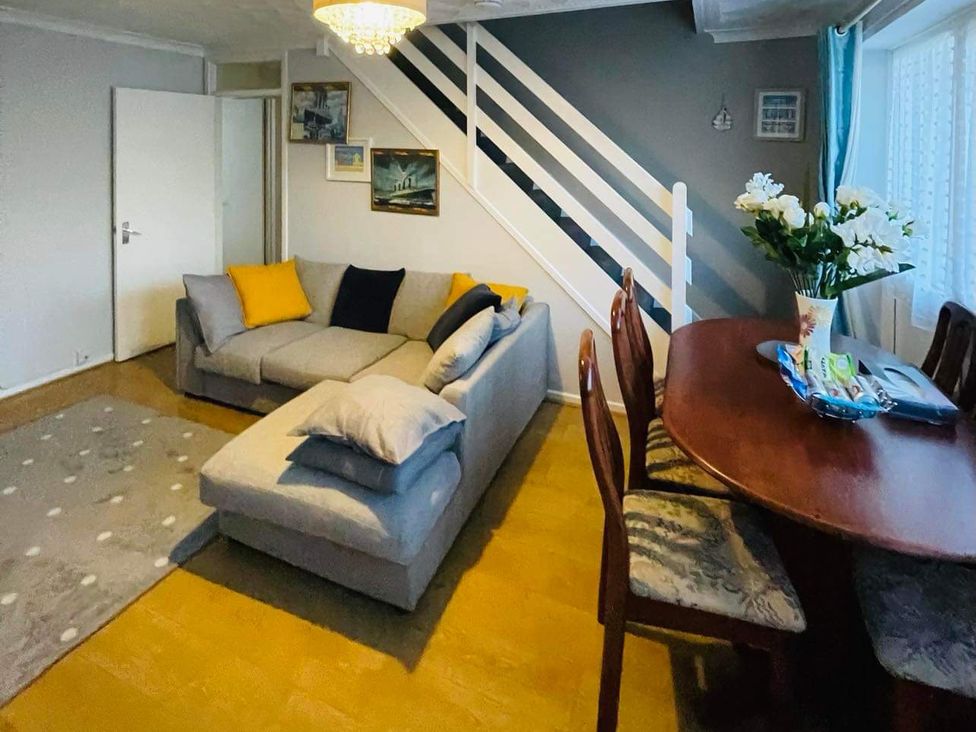 A living room with a sofa and dining table at tbc