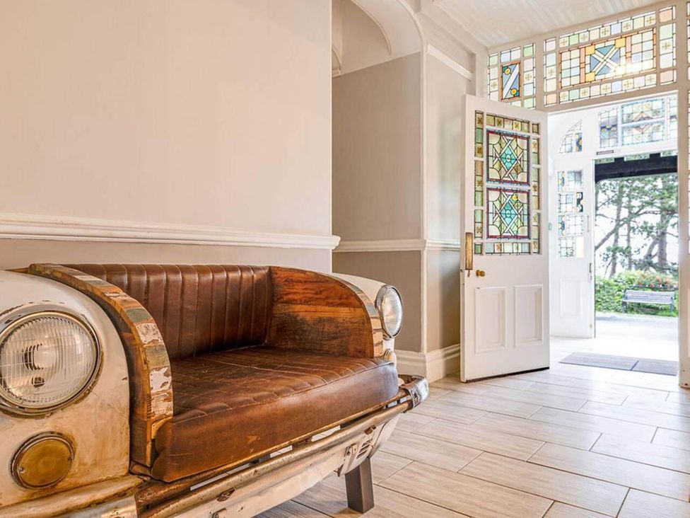 An entrance with a bench and stained glass windows at tbc