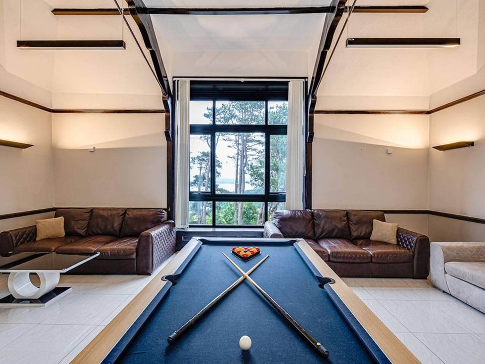 A game room with a pool table and sofas at tbc in 