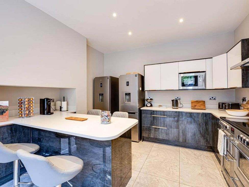 A kitchen with appliances and bar stools at tbc in 