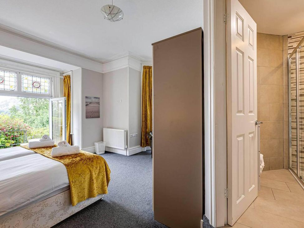 A bedroom with a bed and a door leading to a bathroom at tbc