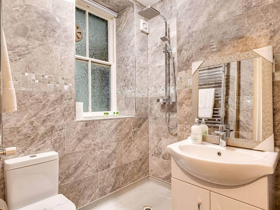 A bathroom with a shower, sink, and toilet at tbc