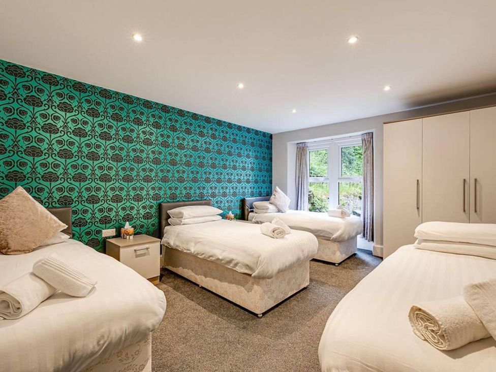 A bedroom with multiple beds and a window at tbc 