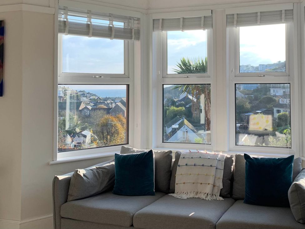 A living room with a sofa and windows showcasing a view at tbc in 