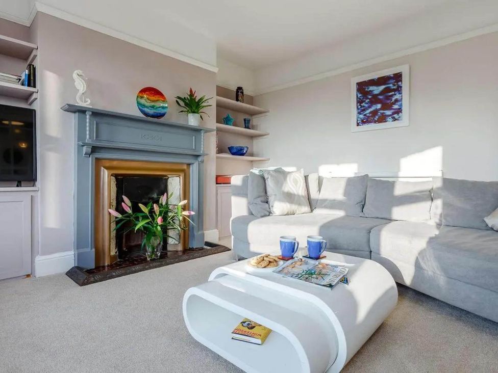 A living room with a sofa, fireplace, and coffee table at tbc in 