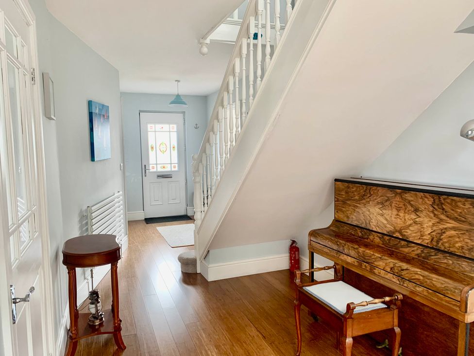A hallway with a piano and staircase at tbc in 