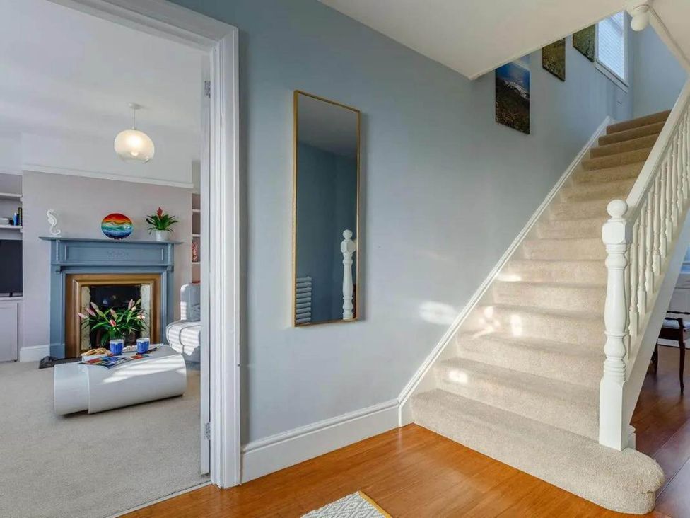 A hallway with a staircase and a mirror at tbc in 