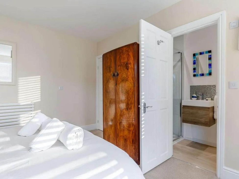 A bedroom with a bed and wardrobe leading to a bathroom at tbc