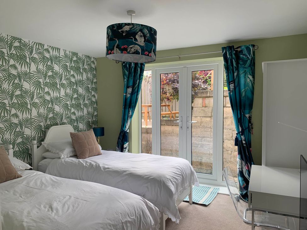 A bedroom with two single beds and a desk at tbc in 