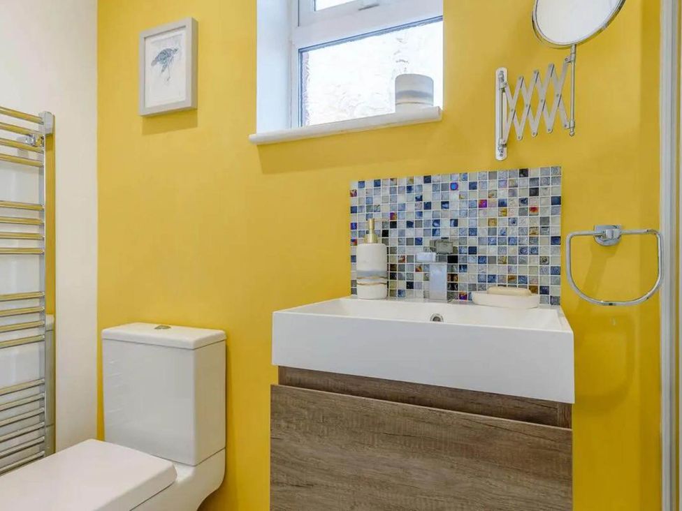 A bathroom with yellow walls and fixtures at tbc 