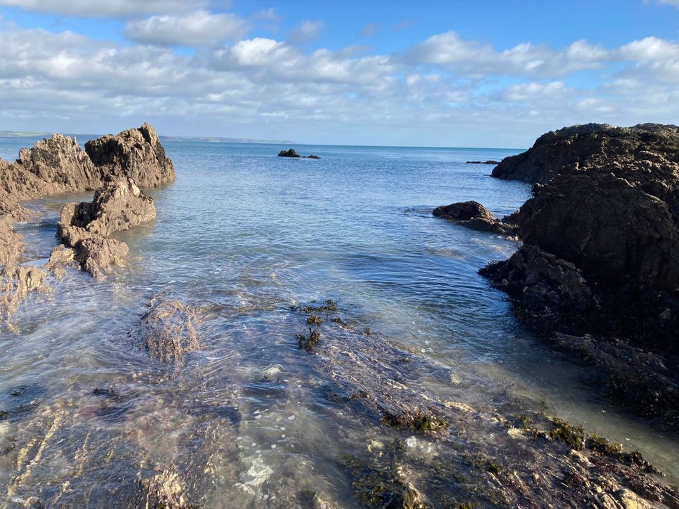 A coastal scene with rocks and calm water at tbc in 