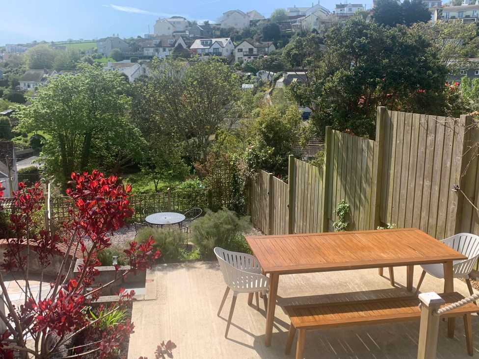 A garden with a wooden table and chairs at tbc in 