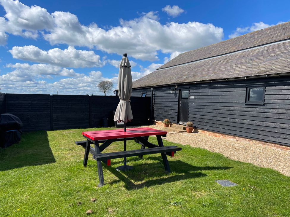 A garden with a picnic table and umbrella at The Old Barn in 