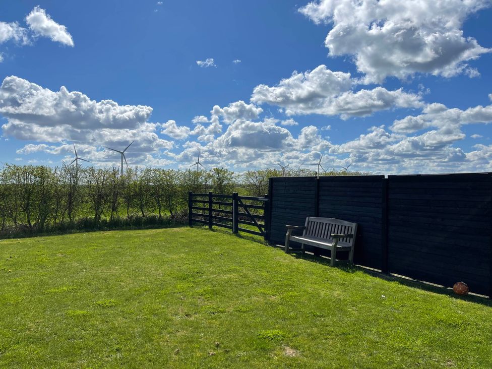 A garden with a bench and a fence at tbc in 