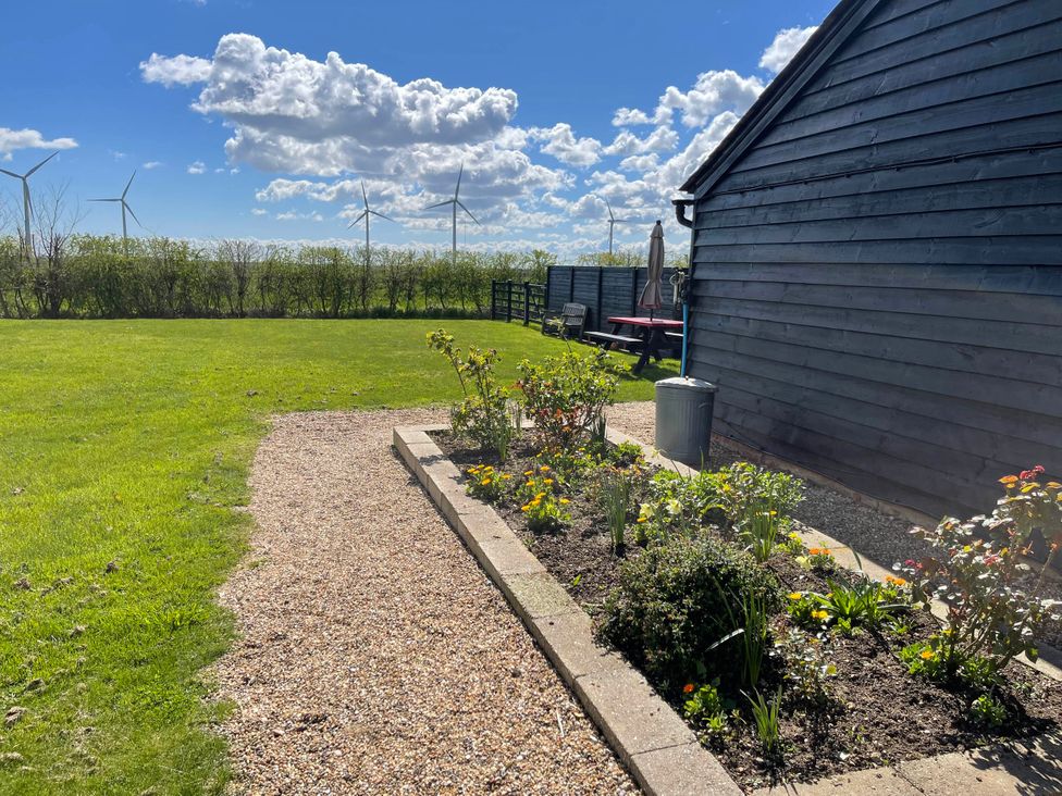A garden with flowers, a table, and wind turbines at tbc in 