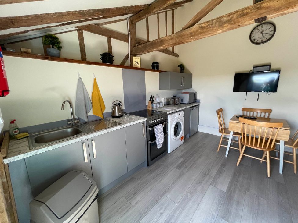 A kitchen with appliances and seating area at The Old Barn in Manchester