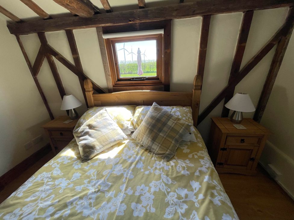 A bedroom with a bed and nightstands at tbc