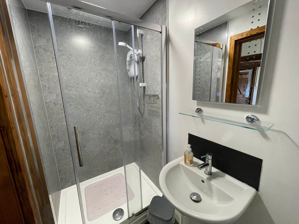 A bathroom with a shower and sink at tbc 