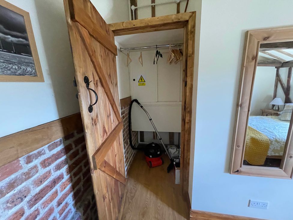 A storage room with a vacuum cleaner and hanging space at tbc