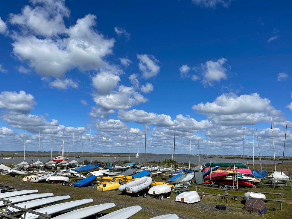 A marina with various boats and sailboats parked at a water's edge at tbc 