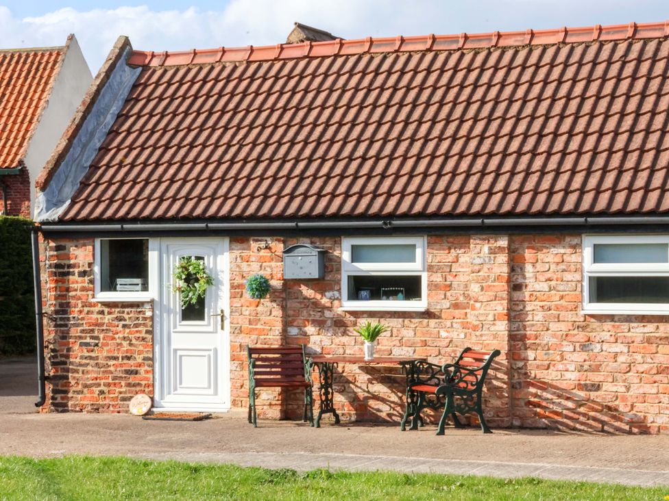 An outdoor view of a brick cottage with a table and chairs at Lamb Cottage Stockton-On-Tees