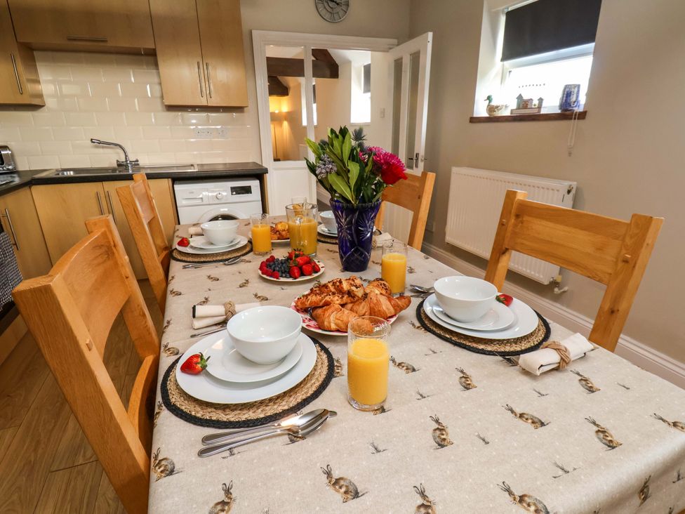 A dining room with a table set with dishes and food at Lamb Cottage Stockton-On-Tees