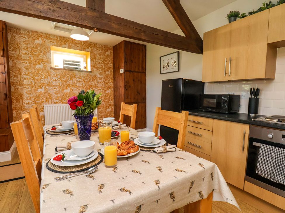 A kitchen with a dining table and kitchen appliances at Lamb Cottage Stockton-On-Tees