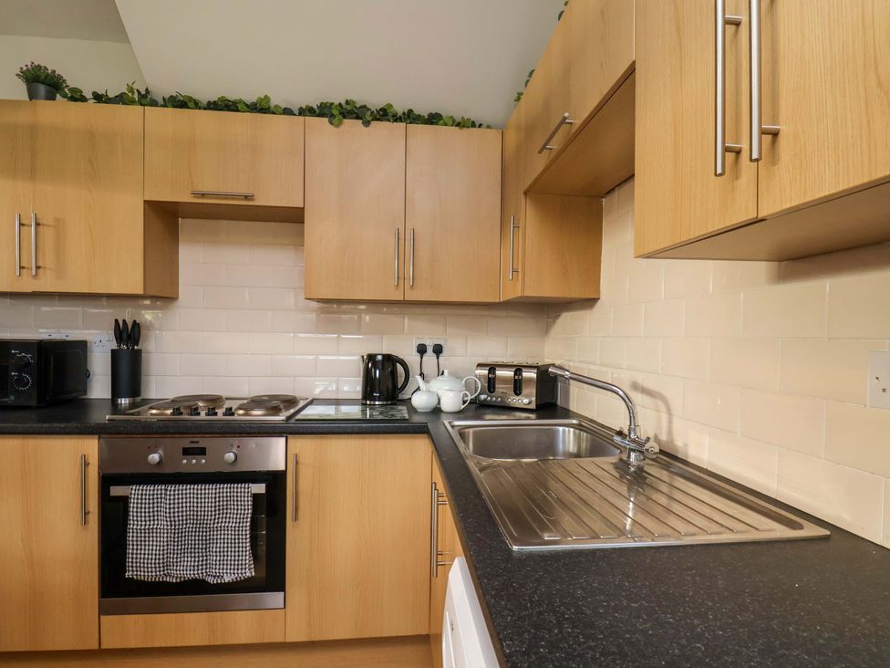 A kitchen with appliances and cabinets at Lamb Cottage Stockton-On-Tees