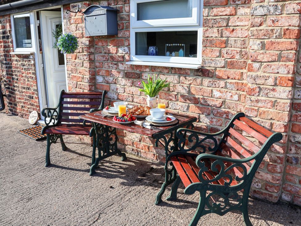 An outdoor dining area with a table and chairs at Lamb Cottage Stockton-On-Tees