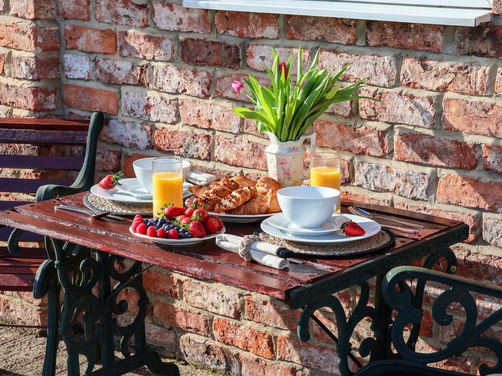 An outdoor dining area with a table set for breakfast at Lamb Cottage in Stockton-On-Tees