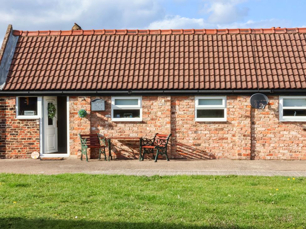 A cottage exterior with seating and a door at Lamb Cottage Stockton-On-Tees
