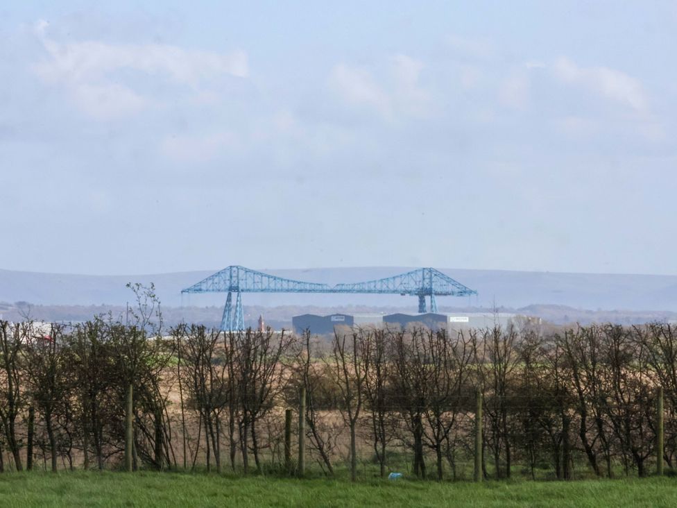 A bridge and buildings in the distance with trees in the foreground at Lamb Cottage Stockton-On-Tees
