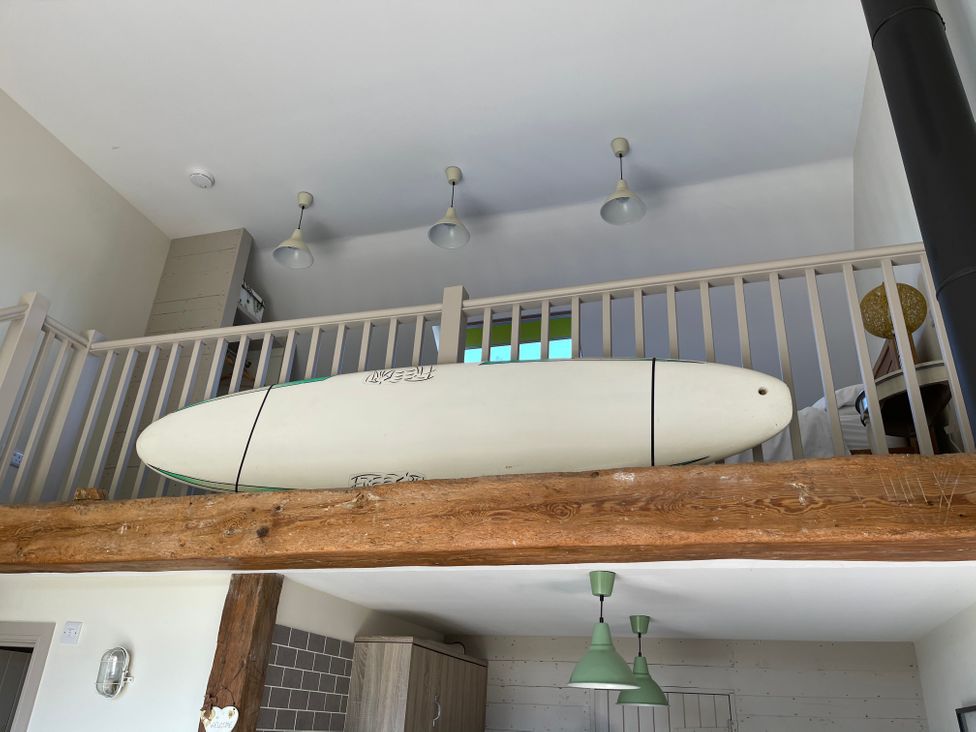 A loft area with a surfboard and light fixtures at The Old Barn in Manchester