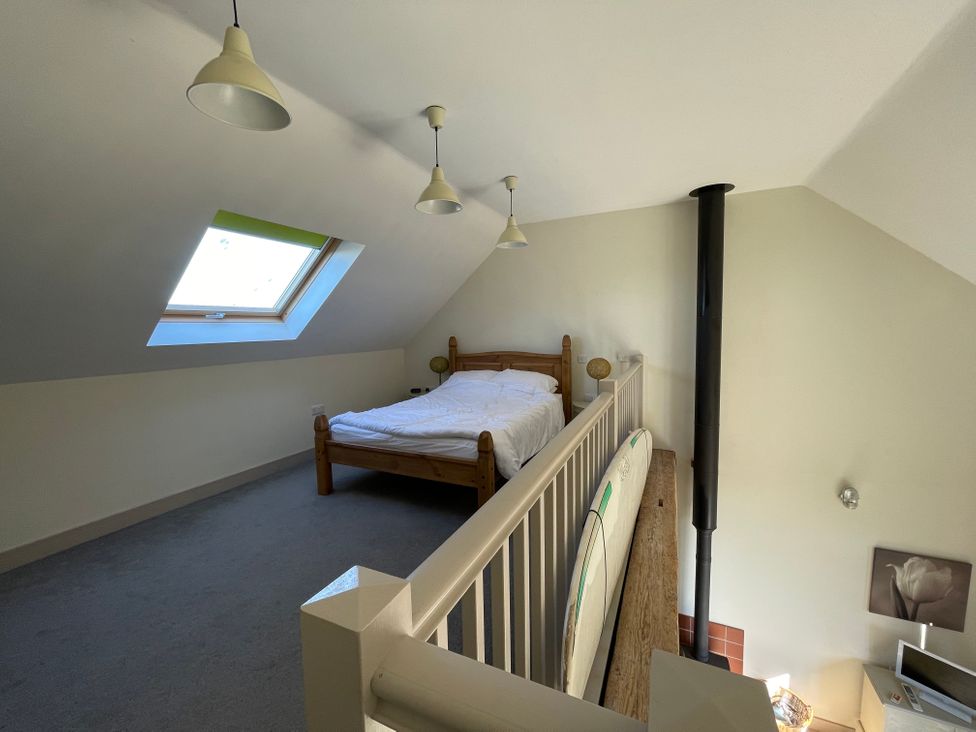 A loft with a bed and skylight at Countryside cottage with wood fire near the coast