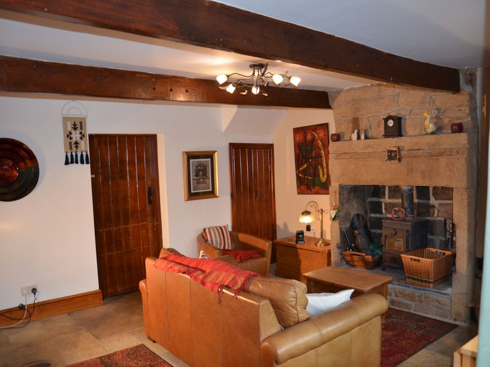 A living room with a fireplace and furniture at tbc