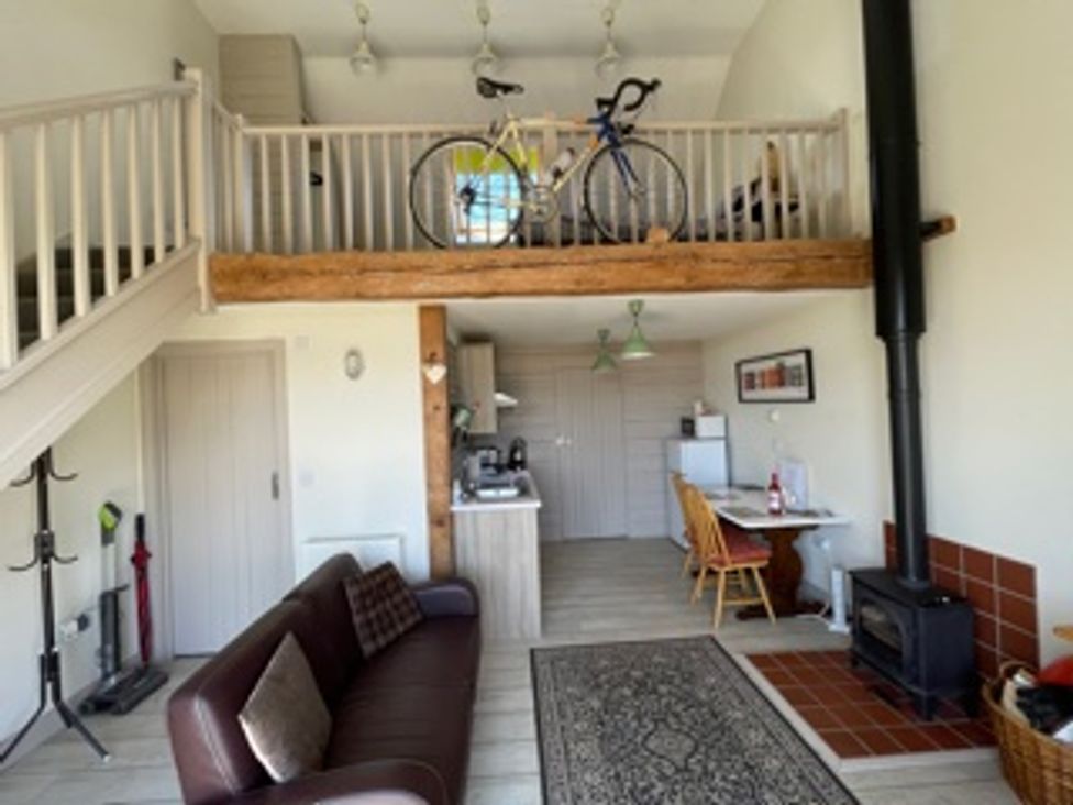A living room with a bicycle and wood stove at tbc