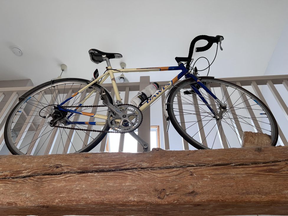 A bicycle on a wooden beam in a hallway at tbc