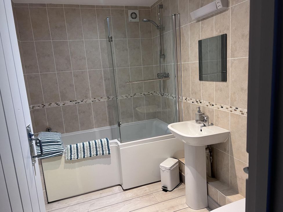 A bathroom with a shower and bathtub at tbc