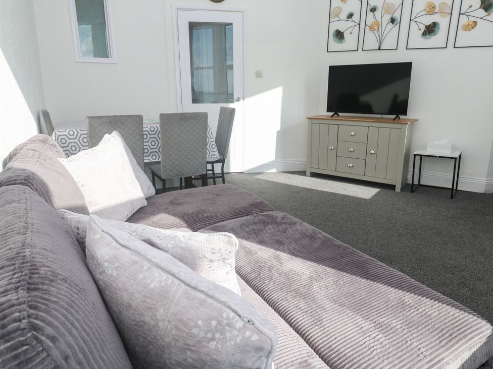 A living room with a TV and dining area at Flat 2 in Penzance