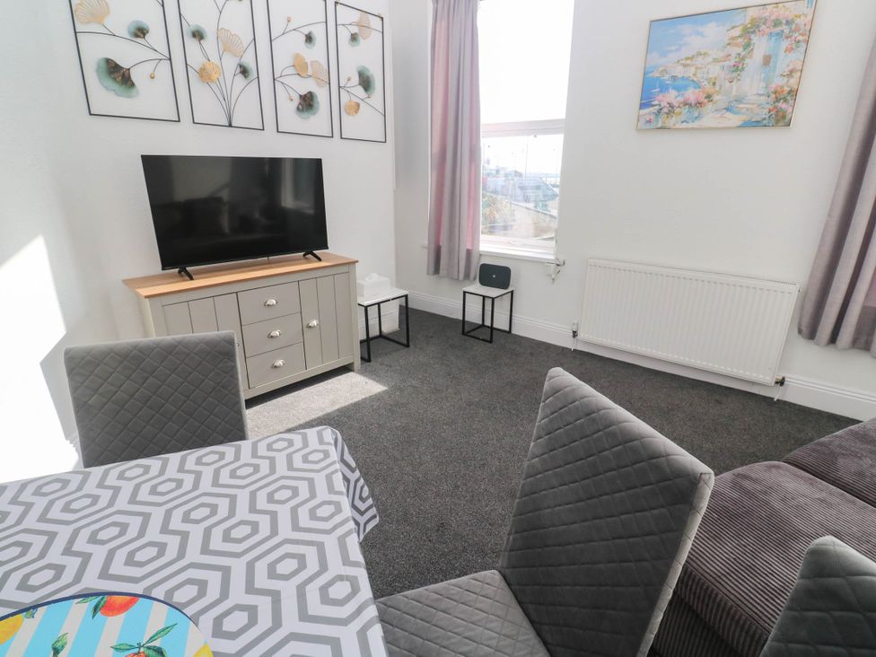 A living room with a TV and seating area at Flat 2 in Penzance