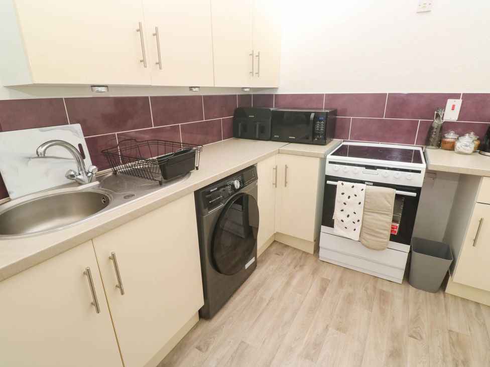 A kitchen with appliances including a washing machine and oven at Flat 2 in Penzance