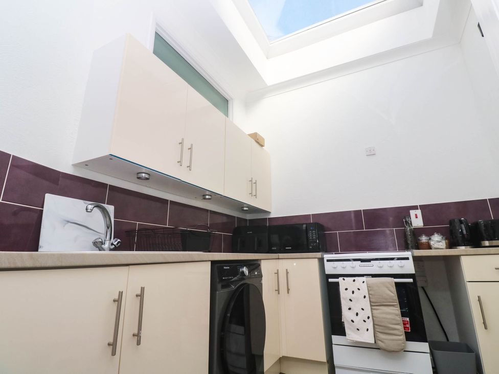 A kitchen with cabinets and appliances at Flat 2 in Penzance