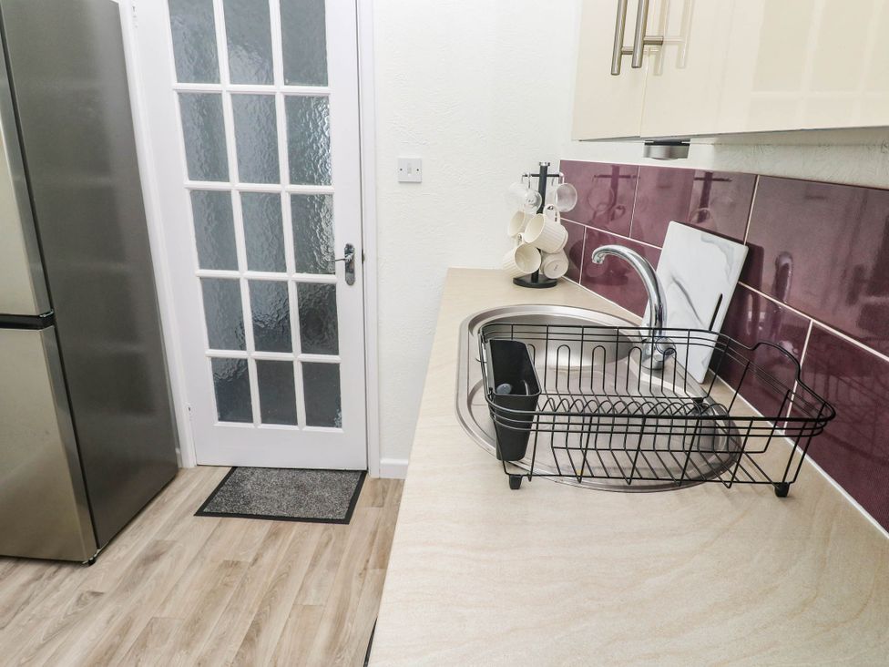 A kitchen with a sink and refrigerator at Flat 2 in Penzance