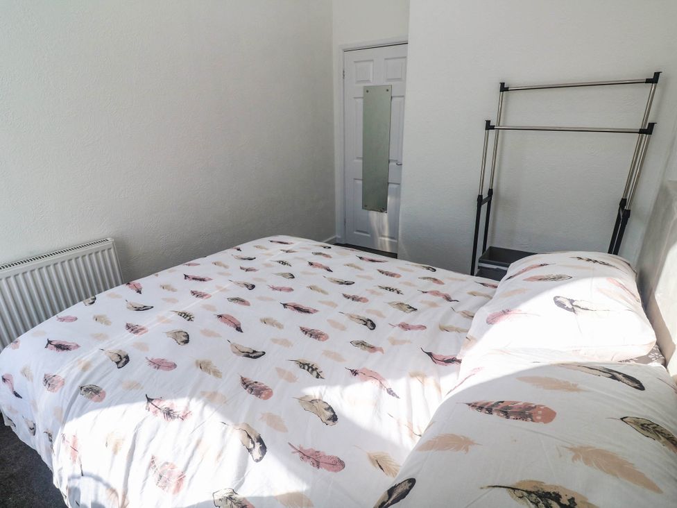 A bedroom with a bed and a hanging rack at Flat 2 in Penzance